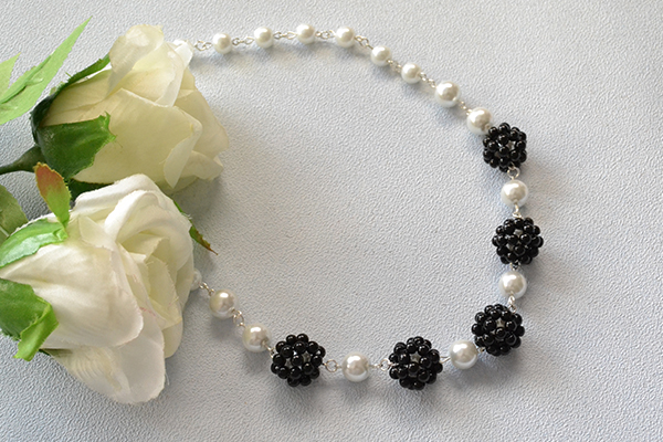 Here is the final look of this elegant white and black pearl beaded ball necklace!