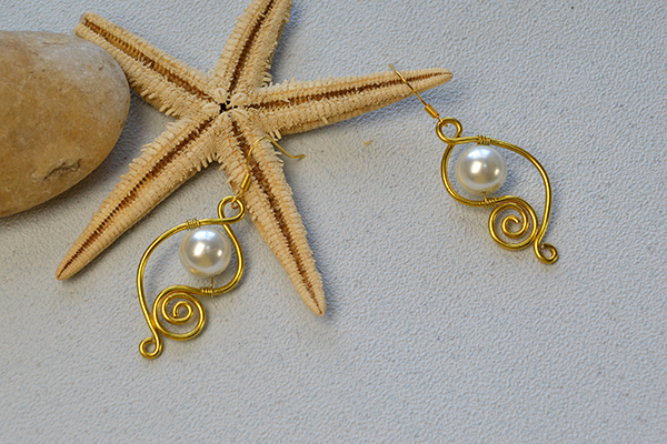 final look of the golden wire wrapped earrings with white pearl beads