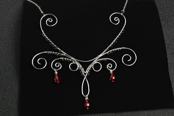 final look of the silver wire wrapped necklace with red drop glass beads