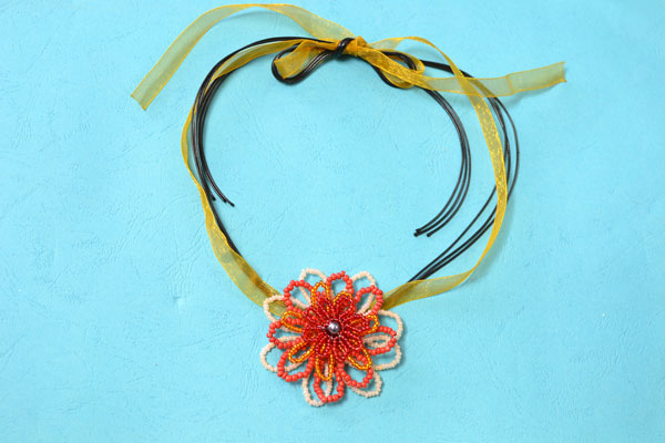 final look of the seed bead flower necklace with orange ribbon and black leather cords
