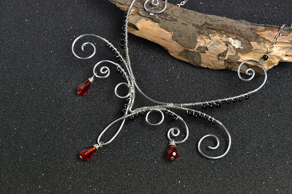 final look of the silver wire wrapped necklace with red drop glass beads