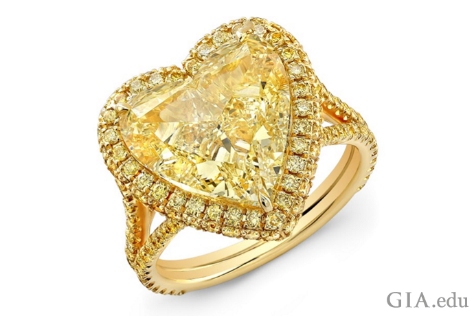 Fancy yellow 7.02 carat (ct) symmetrical heart-shaped diamond surrounded by 1.08 carats of yellow pavé-set diamonds.