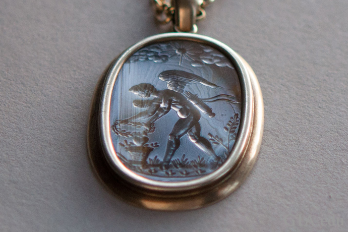 An antique agate intaglio pendant (circa 1600) depicts Eros as a muscular, winged youth. 