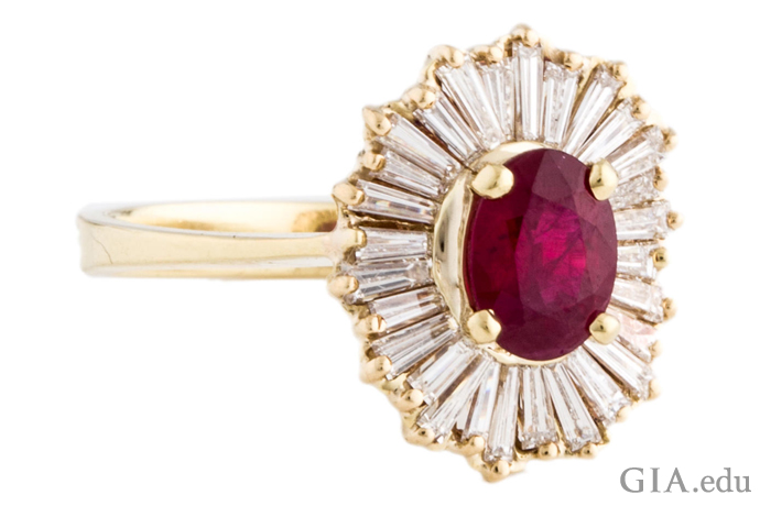 An 18K yellow gold prong-set cocktail ring with a ruby center stone, accented with tapered baguettes to make a “ballerina setting.” 
