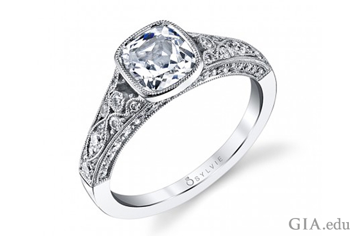An engagement ring featuring a bezel-set 1.00 ct cushion cut diamond, accented by 0.54 carats of diamonds in the shank
