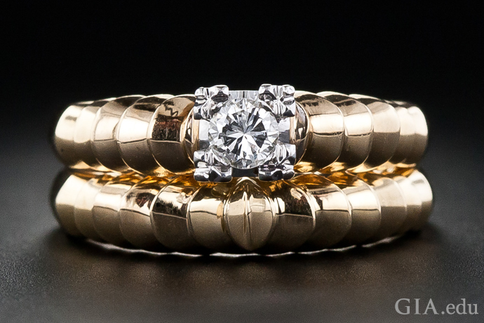 A fluted ribbed motif gives this Retro-era gold engagement ring and wedding band an almost organic appearance.