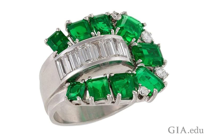 A poetic interpretation of this Retro-era engagement ring – a footbridge of channel-set baguettes is surrounded by tracks of emeralds. 